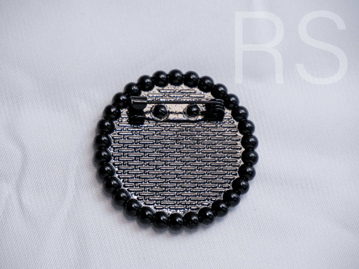 Broche noire à poids